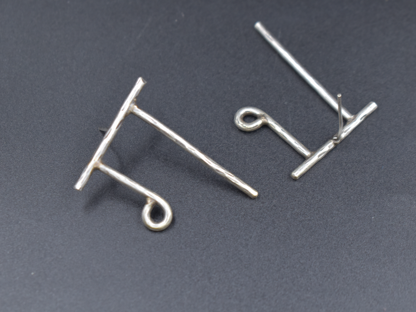 A pair of silver look word earing
